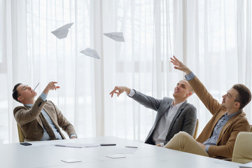 business men throwing paper planes at the board meeting. small break from work to relax. fun...