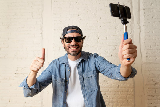 young attractive latin man taking a selfie with his smart cell phone.