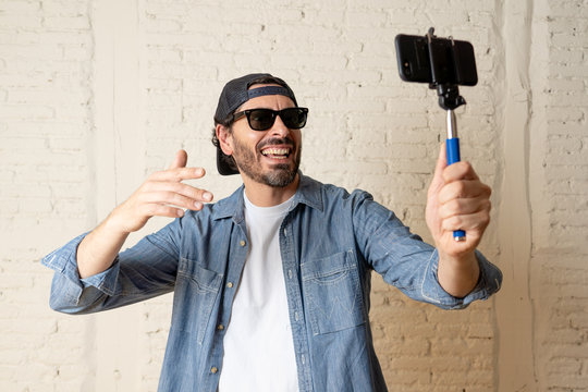 young attractive latin man taking a selfie with his smart cell phone.