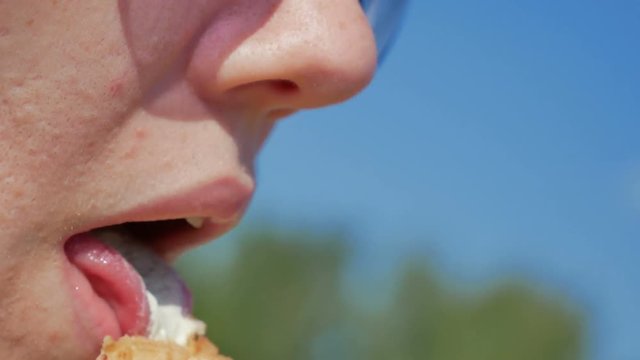 Girl in licks ice cream in waffle cup. Close-up shot. Sunny day
