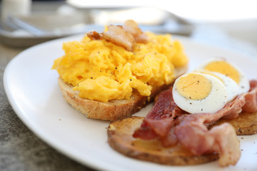 breakfast with scrambled eggs, fried potatoes bacon and shrimp