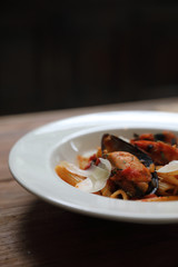 Penne pasta tomato sauce arabiata with seafood on wood background vintage style