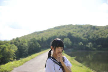 Naklejka premium Portrait of Asian Japanese school girl looking in country side background