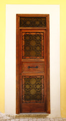 Old and aged historic door in ocher wood in the city of San Felice Circeo (seaside), Lazio, Italy