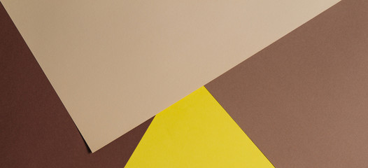 Color papers geometry composition background with brown, beige and yellow tones.