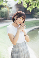 portrait of asian girl with white shirt and skirt looking in outdoor nature vintage film style