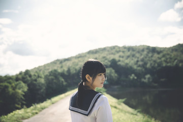 Portrait of asian japanese school girl costume looking at park outdoor film vintage style