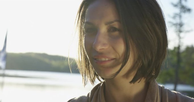 Woman at cottage during sunset turns to face camera - close up -  slow  motion