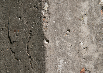 Old flaky white paint peeling off a grungy cracked wall. Cracks, scrapes, peeling old paint and plaster on background of old cement wall. An old cement stone wall as vintage cracked.