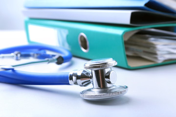 books folder file, stethoscope, red heart and RX prescription isolated on white background.