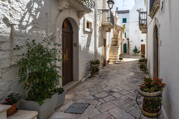 A narrow street decorated with flowers in Locorotondo, Apulia, Italy