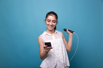 Girl with phone and power bank in hands Young beautiful woman smiles with a phone and charging in...