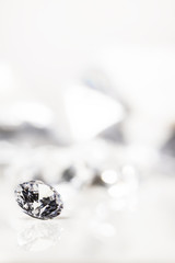 Diamant auf weiß mit Spiegelung vor weißem Hintergrund, mehrere Diamanten in der Unschärfe, Edelsteine mit Textfreiraum
