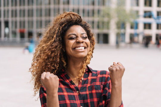 Excited young woman cheering and punching the air