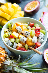 Fruit salad bowl with tropical fruits. Mango, pitaya, coconut, pineapple, strawberry and kiwi salad