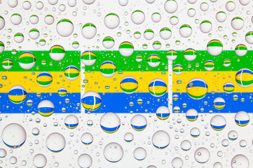 Water drops on glass and flags of Gabon