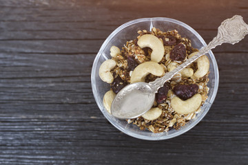 Cup of granola with cashews on a black wooden table. Top view. Traditional American Breakfast