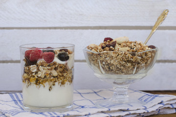 Granola with berries and yogurt on a wooden table. Traditional American Breakfast