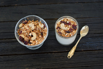 Granola with berries and yogurt on a black wooden table. Traditional American Breakfast