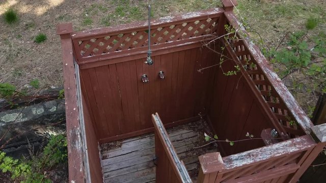 Aerial dolly over the ruins of a wooden outdoor shower