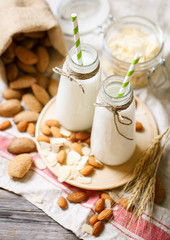 Almond and almond milk on a wooden table in the summer garden. Useful food.