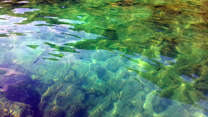 Sea surface aerial view of crystal clear green turquoise rippled sea water and clownfish for background at tropical sea Krabi, Andaman sea, Thailand. Vacation holiday tourism summer beach concept.