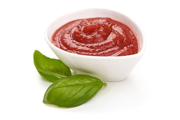 Bowl of ketchup or tomato sauce with herbs, isolated on white background.