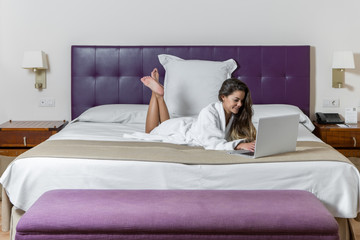 Obraz na płótnie Canvas Happy girl with laptop in modern hotel