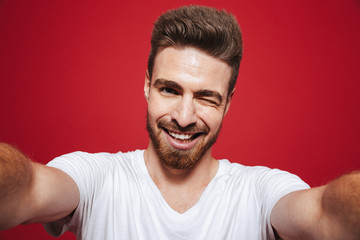 Obraz premium Portrait of a cheerful young bearded man winking