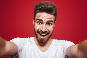 Portrait of a cheerful young bearded man taking a selfie