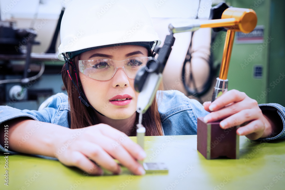 Wall mural female industrial engineer wearing hard hat work on desk at factory.