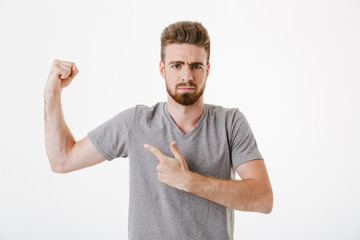 Portrait of a confident young bearded man pointing