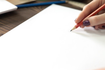 the girl draws a pencil in a notebook