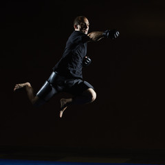 Fototapeta na wymiar A man in a black T-shirt beats with his hand in a jump