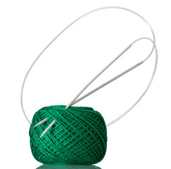 Hank of green cotton yarn and knitting needles isolated on white background