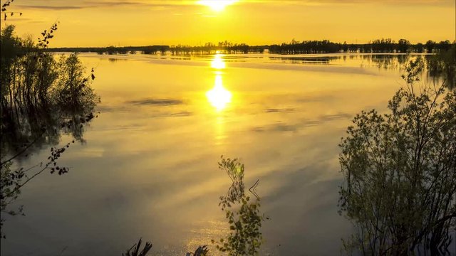 The sun over the channel slowly sinks down the horizon and begins to darken 