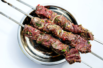 raw skewers of beef with spices and herbs