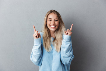 Portrait of a cheerful young girl in blue sweatshirt