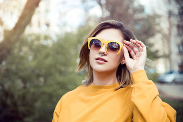 Young pierced woman wearing sunglasses