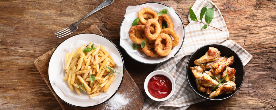 Fast food snacks - onion rings, fries and chicken wings