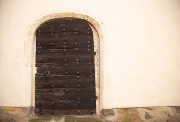 Fototapeta premium Old wooden door on old dirty orange cement wall 