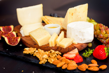 Cheese plate served with grapes, jam, figs