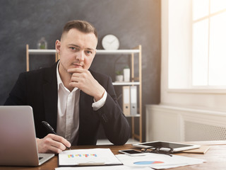Confident businessman sitting at his workplace