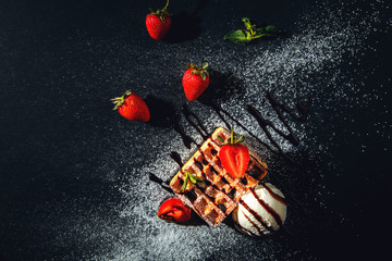 Belgian waffles with ice cream and strawberries.