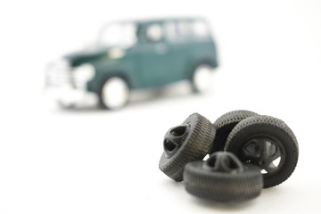 A toy of tire fitting. The car is next to the tires.
