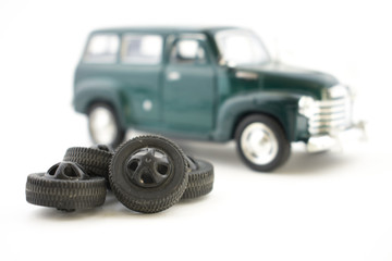 A toy of tire fitting. The car is next to the tires.