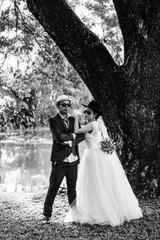 couple getting married shot outdoor in a field with selective focus in black and white