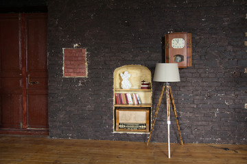 Interior of the room with a lamp, books, radio and wall clock
