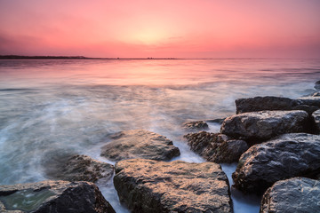 Obraz premium sunrise from the sea with rocks
