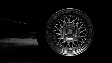 Aluminium rim at racing car in shadow. -monochrome